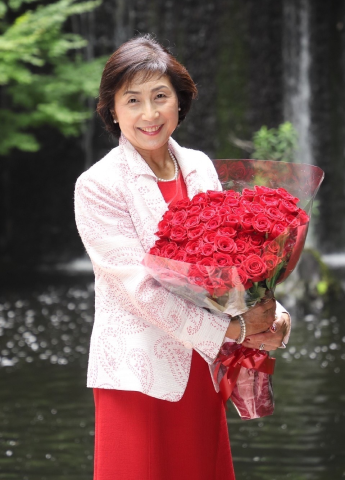 赤いバラを手にした店主の平井敦子